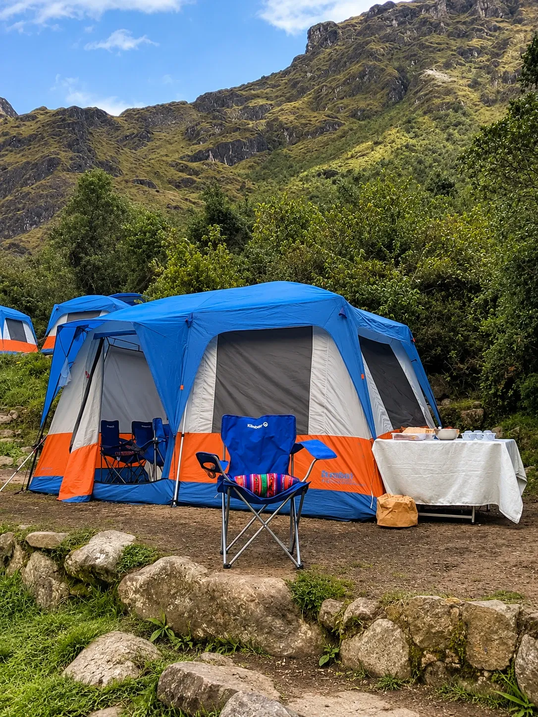 A stand-up tent with chairs set outside at a trek camp