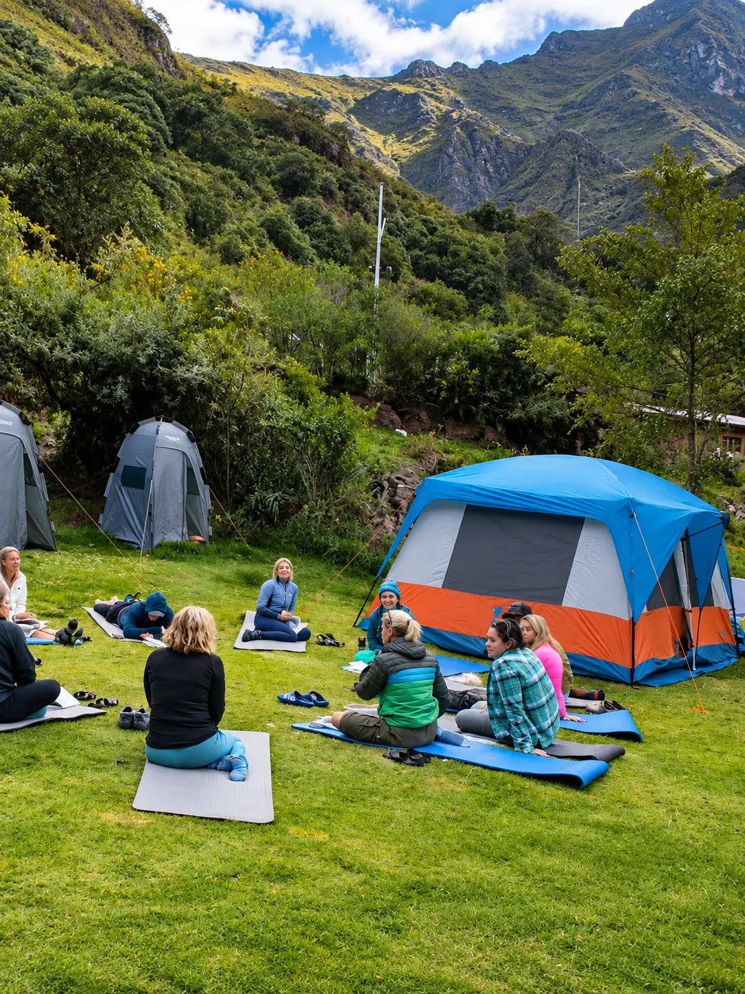 Walkers stretching on the grass beside their tent in camp