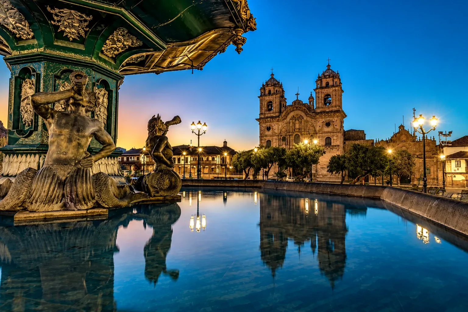 The fountain and Jesuit church on Cusco's main square at dusk