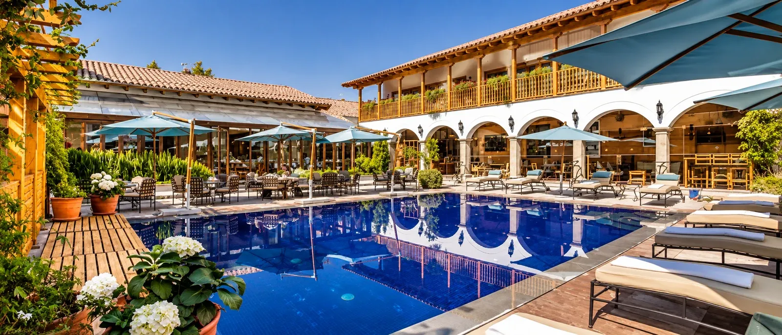 A hotel pool and arcaded terrace under an Andean sky