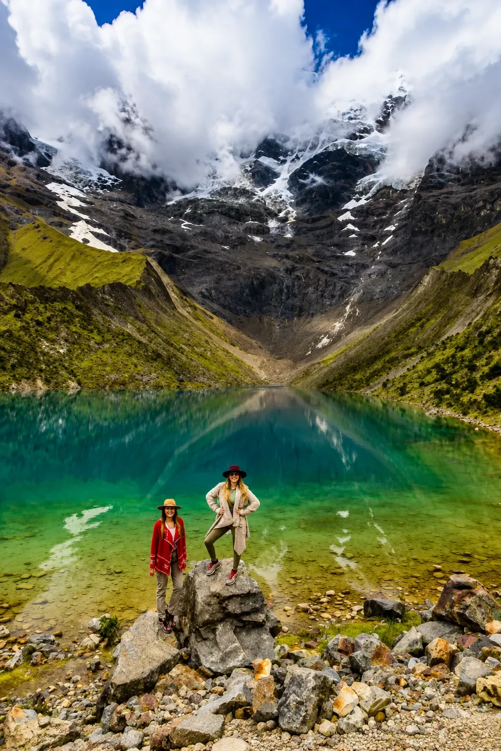 Two walkers on the shore of Humantay Lake