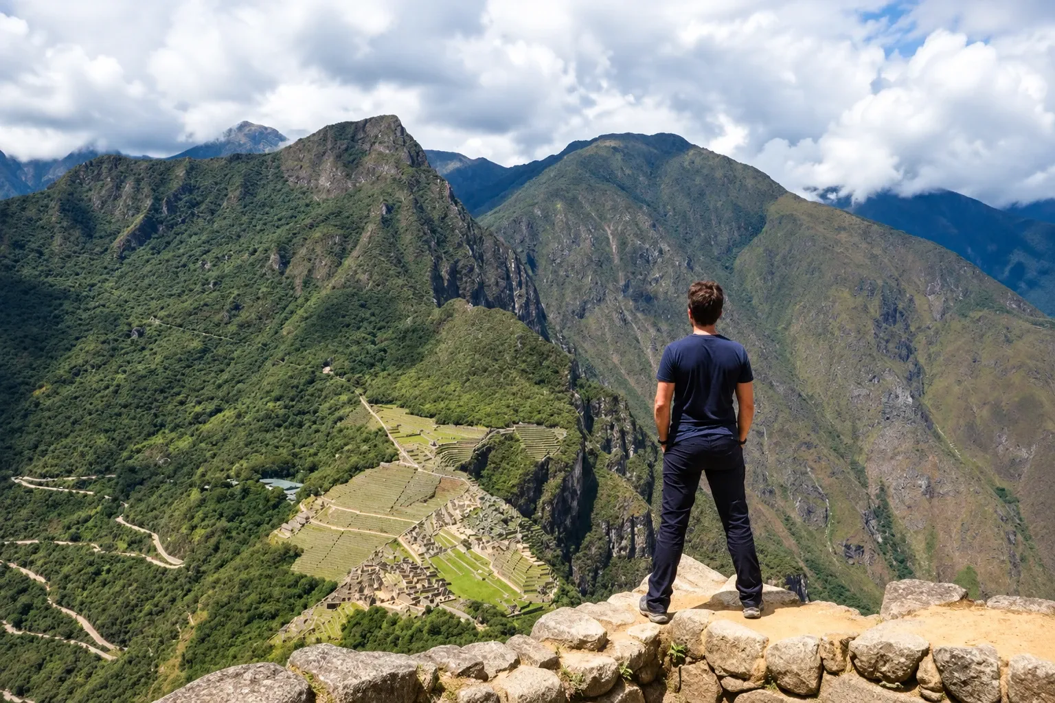 A walker looking across the valley to Machu Picchu from the Llactapata ridge