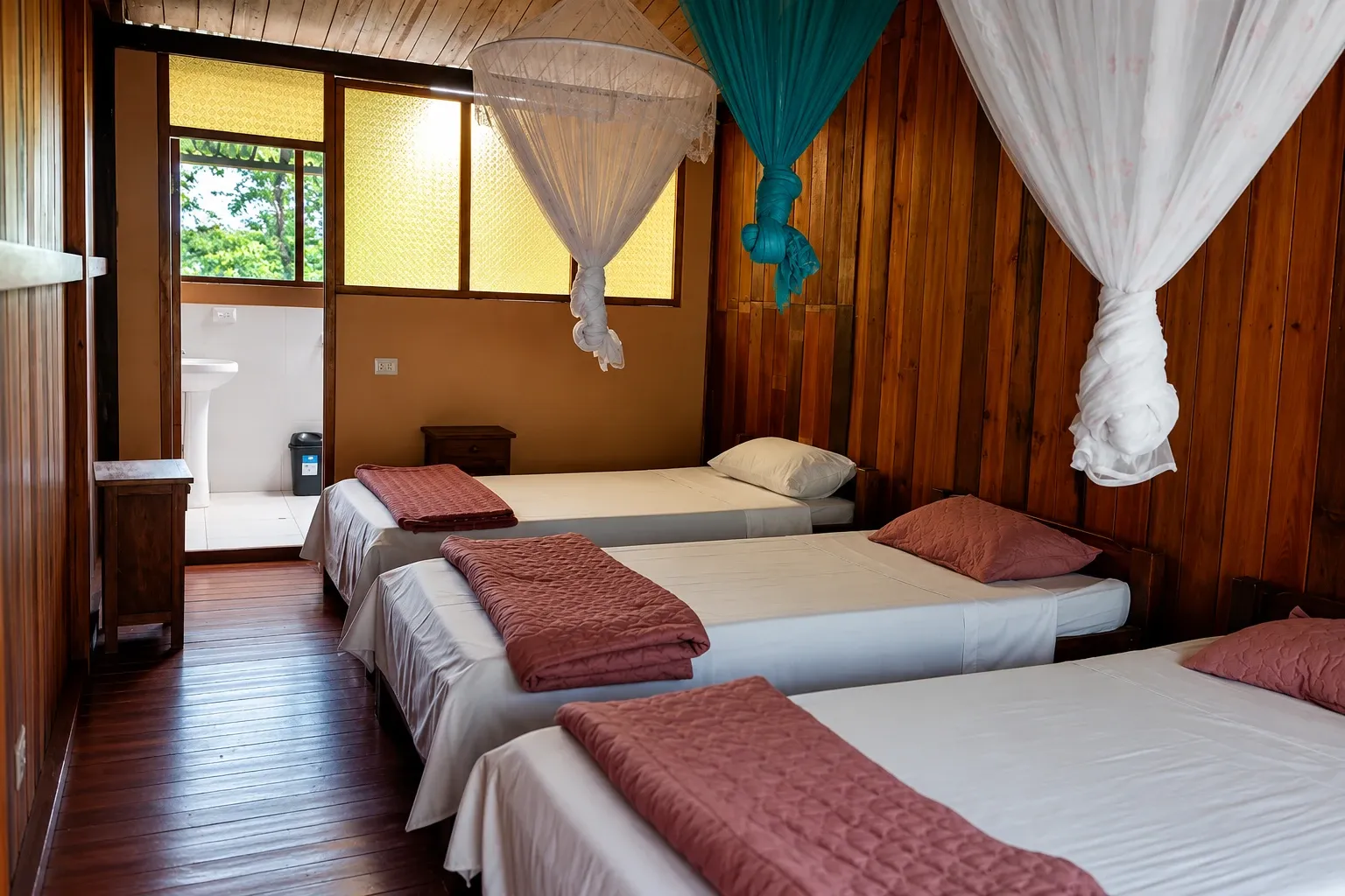 A wood-panelled lodge room with mosquito nets over the beds