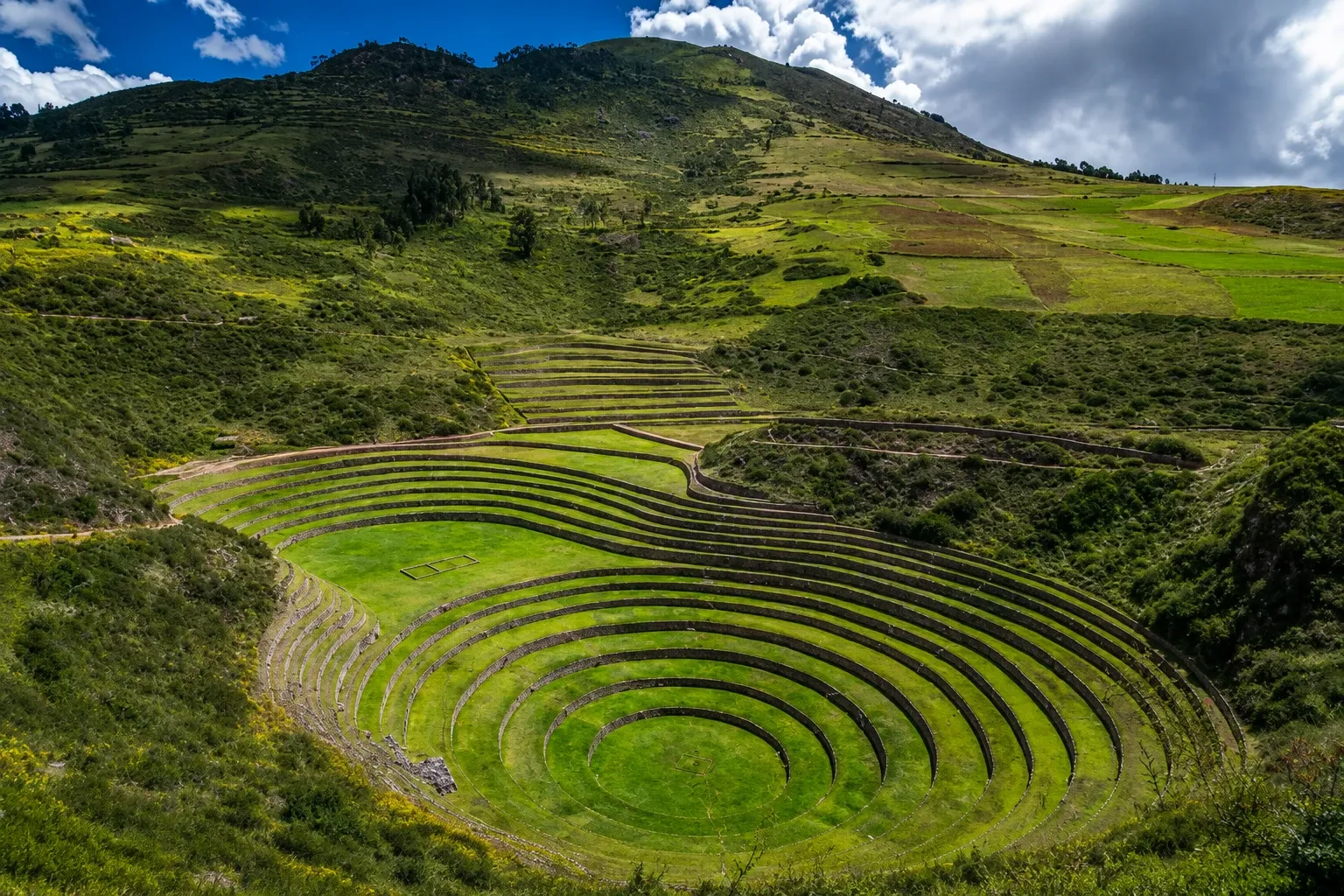 The circular terraces of Moray under a wide Andean sky