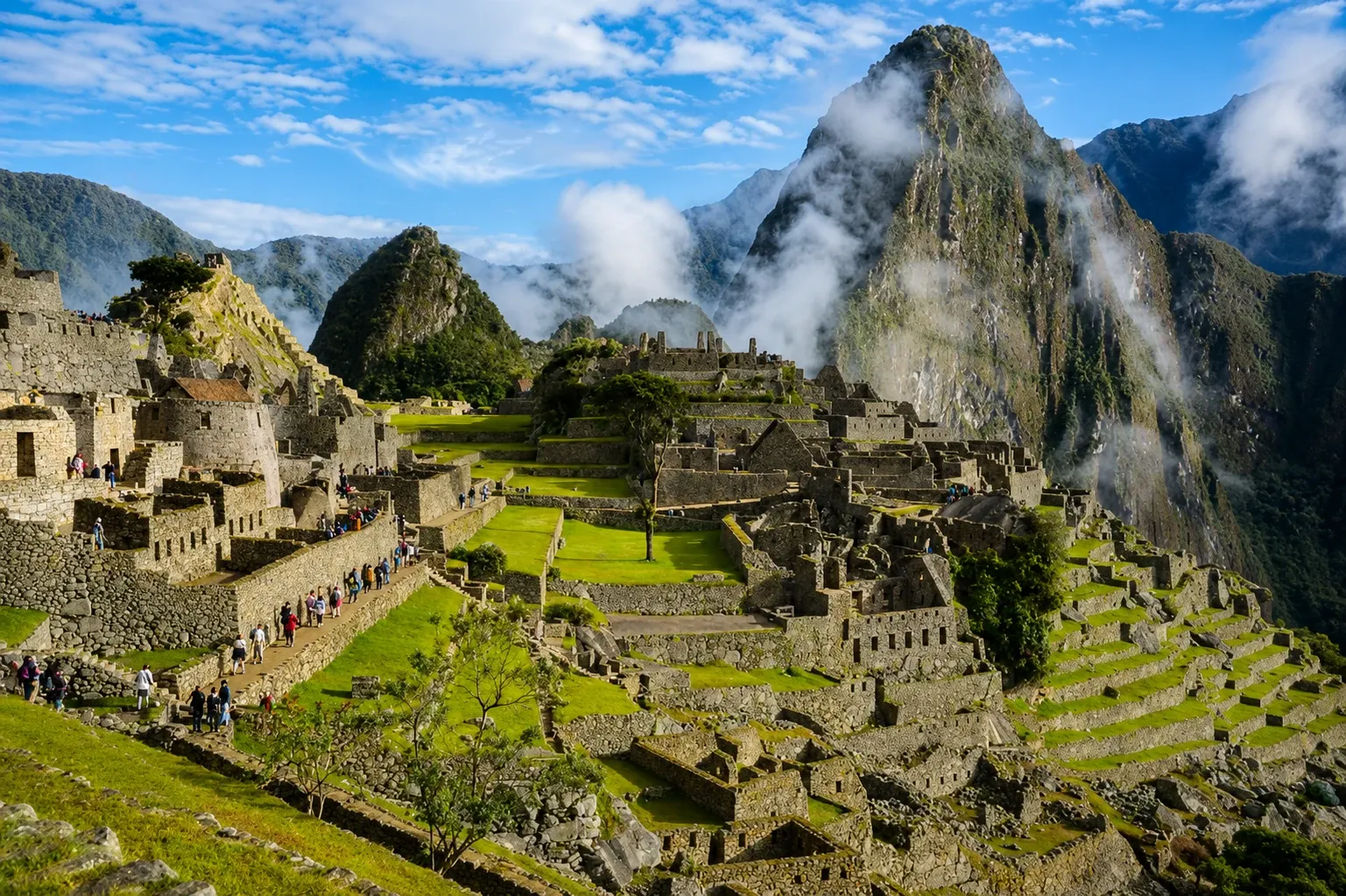 Machu Picchu's stonework with mist lifting off Huayna Picchu