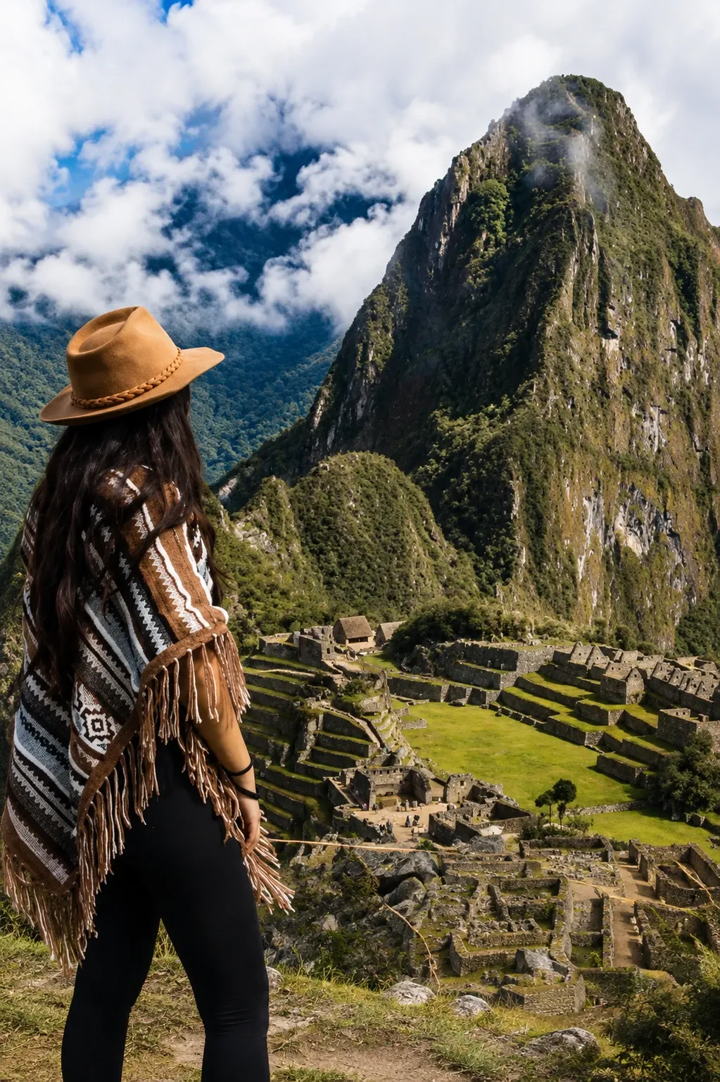 A traveller in a woven poncho looking across to Huayna Picchu