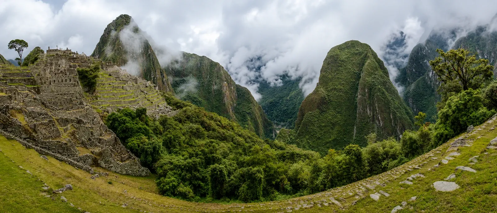 A wide view over Machu Picchu's upper terraces to the peaks around it