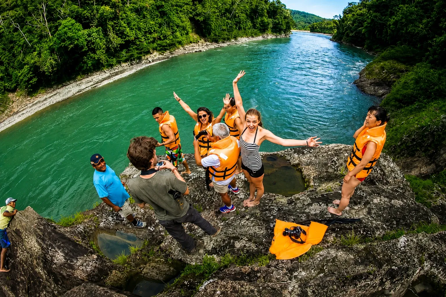 A group on the rocks beside a green river