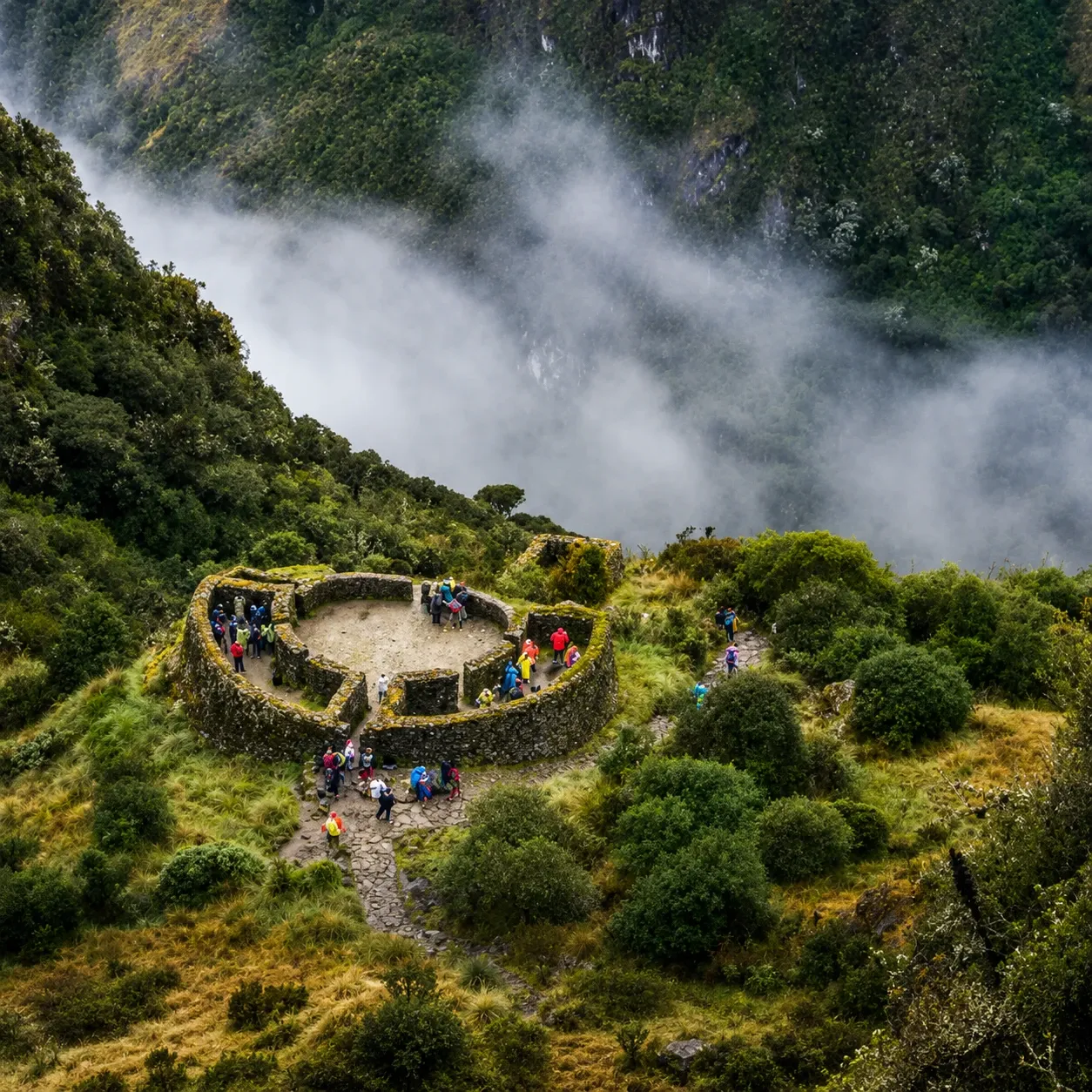 The circular ruin of Runkurakay on its ledge above the cloud
