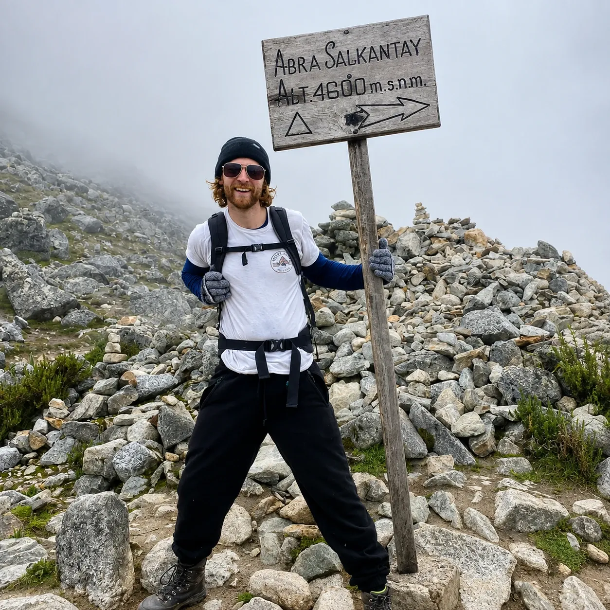 A walker at the cairns and sign marking the Salkantay Pass