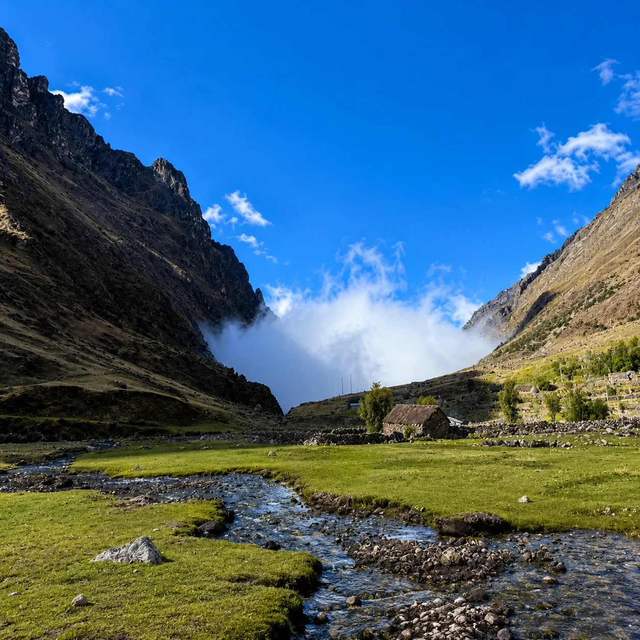 A stream running down a green valley on the Salkantay route
